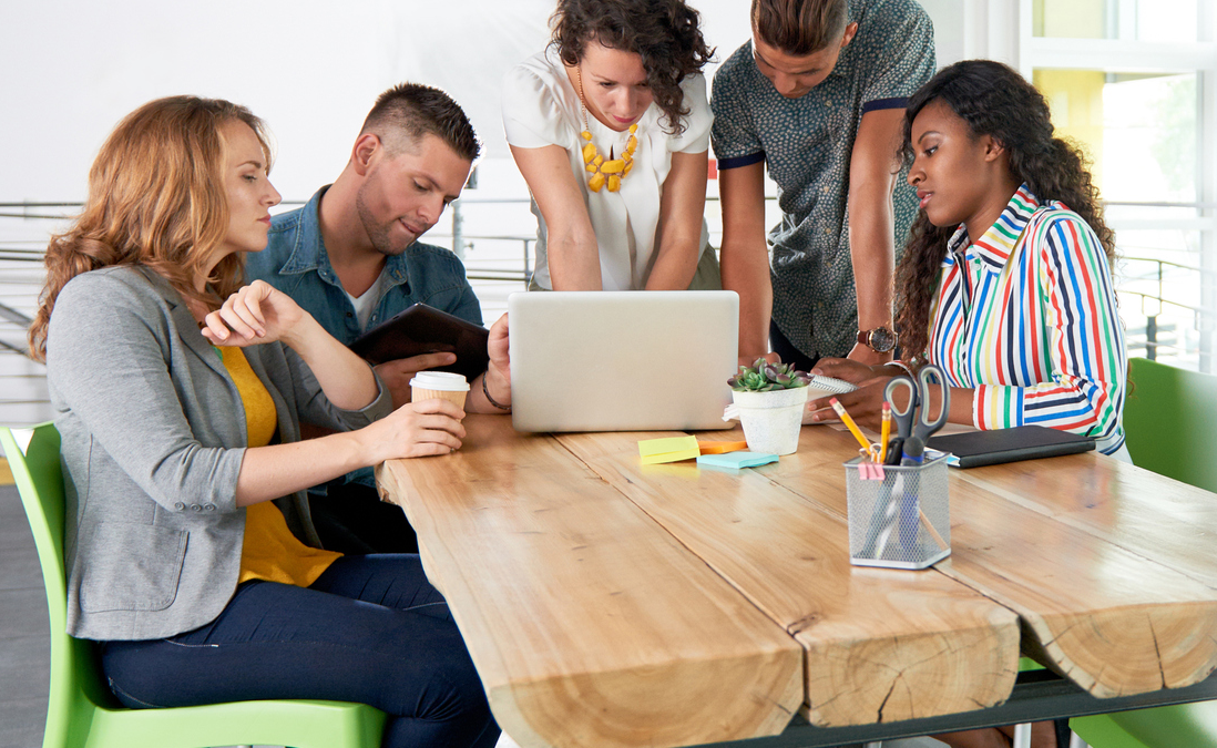 Millennial group around laptop