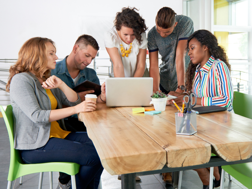 Millennial group around laptop