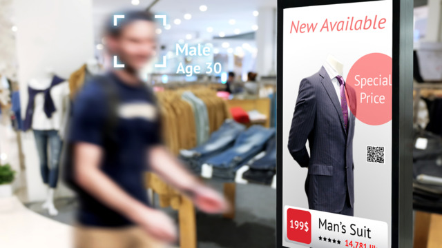 male in retail store next to printed sign